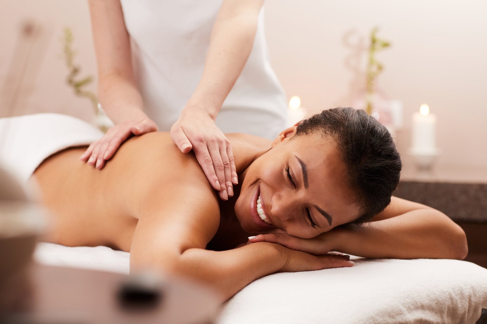 Portrait of beautiful woman smiling happily while enjoying massage in luxury spa